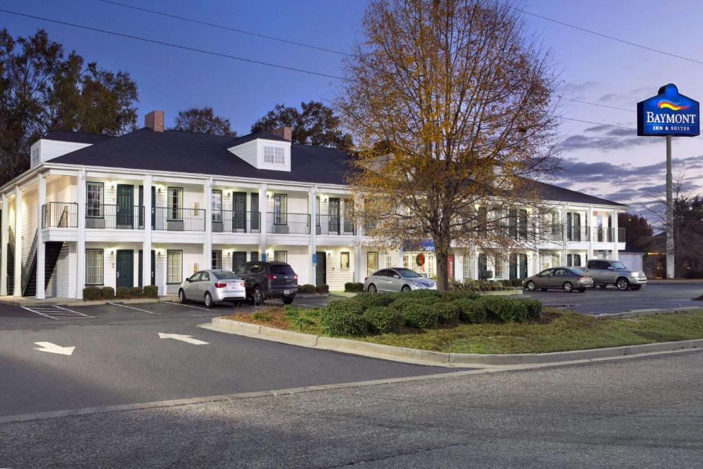 un edificio blanco con coches estacionados en un estacionamiento en Baymont by Wyndham Eufaula, en Eufaula