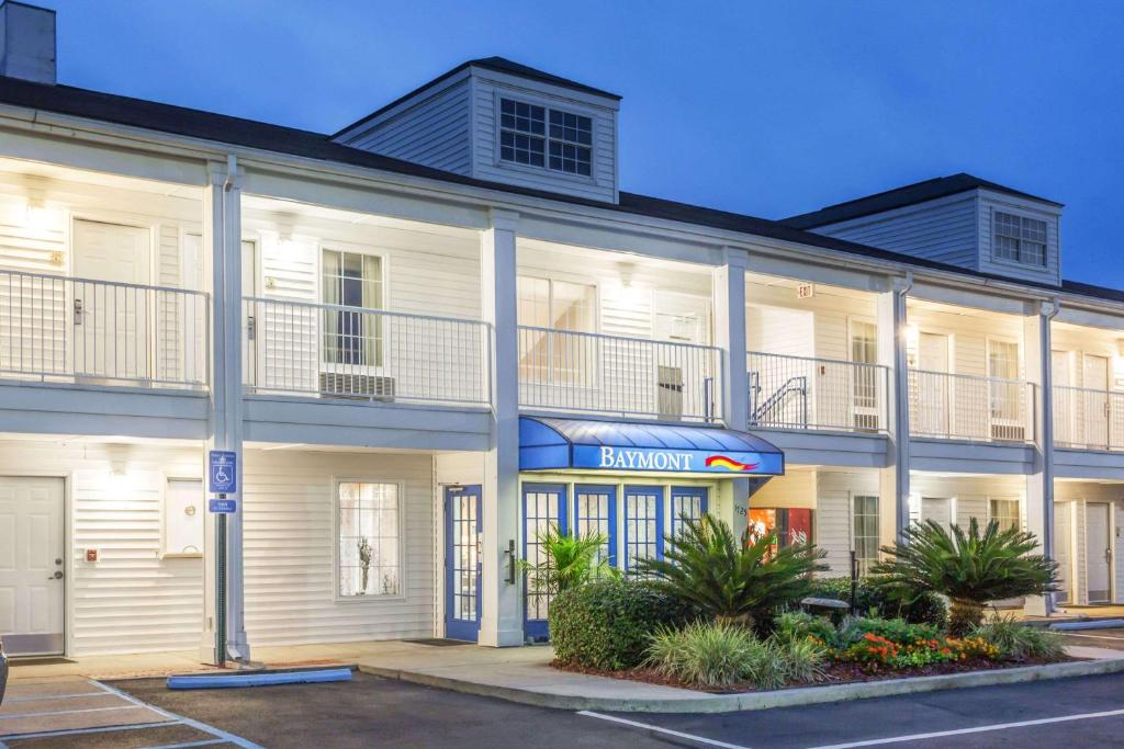 a large white building with a balcony on it at Baymont by Wyndham Valdosta at Valdosta Mall in Valdosta