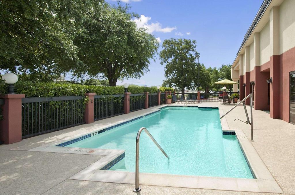 a swimming pool in front of a building at Baymont by Wyndham Lewisville in Lewisville