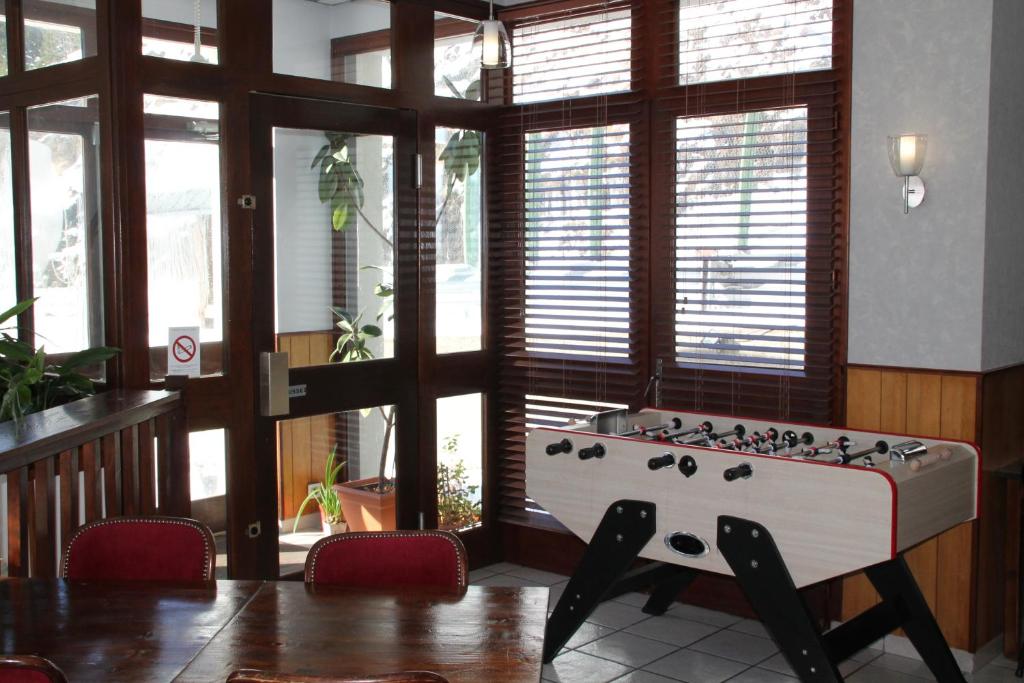 a room with a foosball table in the middle of a room at Hôtel des Chazes in Saint-Jacques-des-Blats