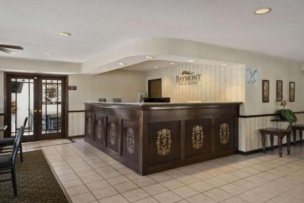 a bar in a restaurant with a counter and chairs at Baymont by Wyndham Whitewater in Whitewater