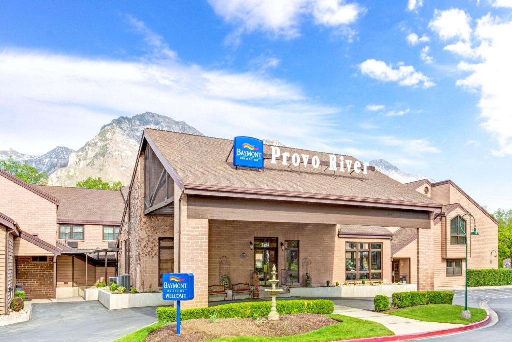 a hotel with a sign on top of a building at Baymont by Wyndham Provo River in Provo