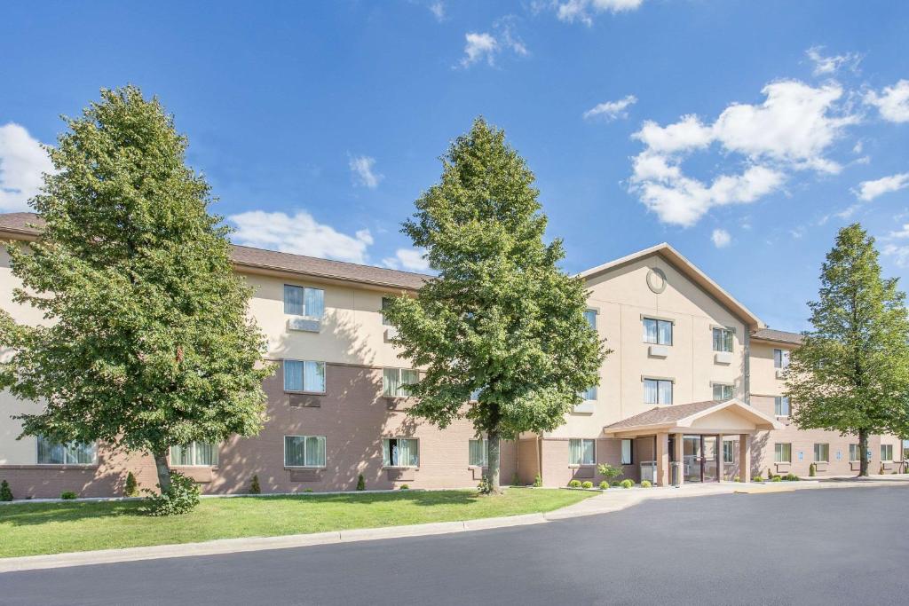 un grand immeuble d'appartements avec des arbres devant lui dans l'établissement Baymont by Wyndham Holland, à Holland