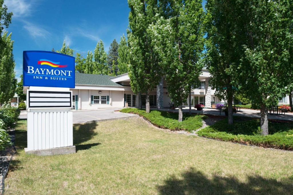 ein Schild vor einem Gebäude mit einem Schild für einen Bankett-Gasthof und eine Suite in der Unterkunft Baymont by Wyndham Coeur D Alene in Coeur d'Alene