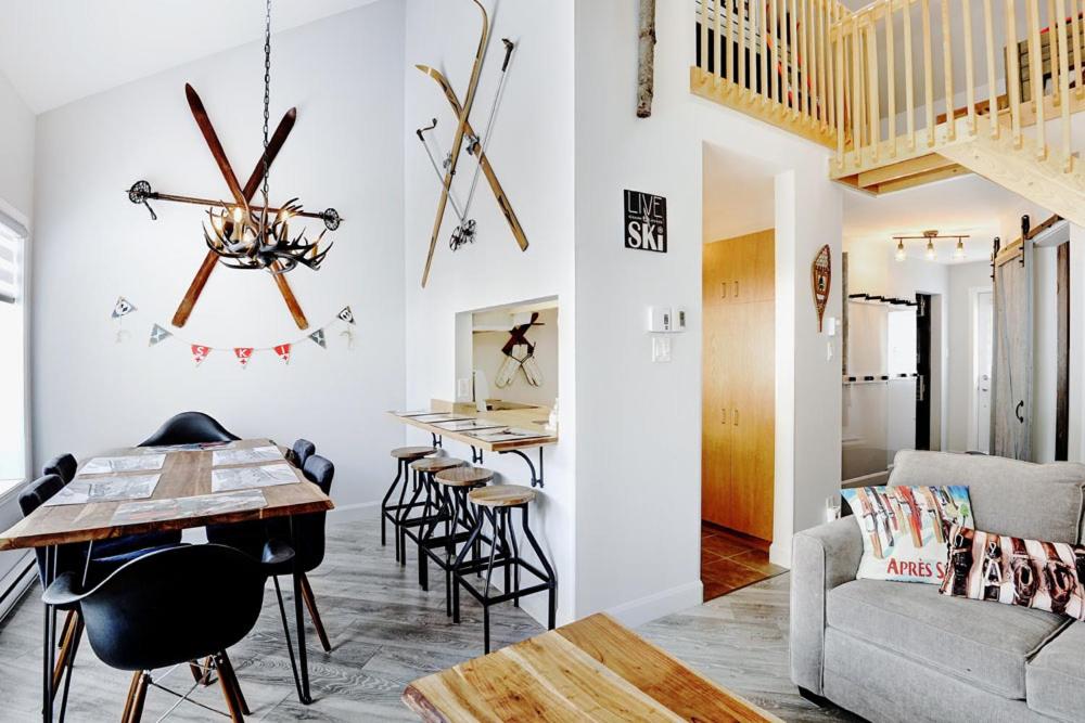 a living room with a table and chairs and a couch at Condo 304 33 Chemin du Hameau by Les Chalets Alpins in Stoneham