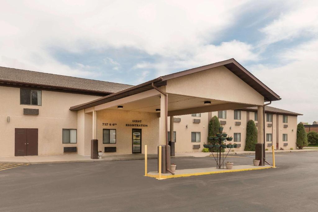 a building with a parking lot in front of it at Baymont by Wyndham Hot Springs in Hot Springs