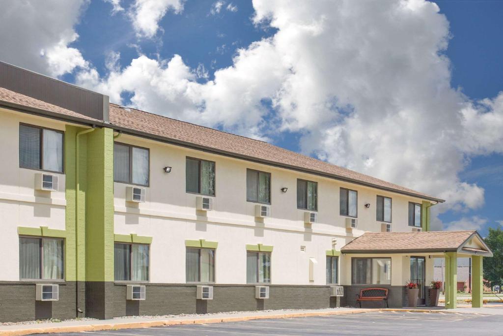 a white and green building with a sky in the background at Baymont by Wyndham Ames in Ames