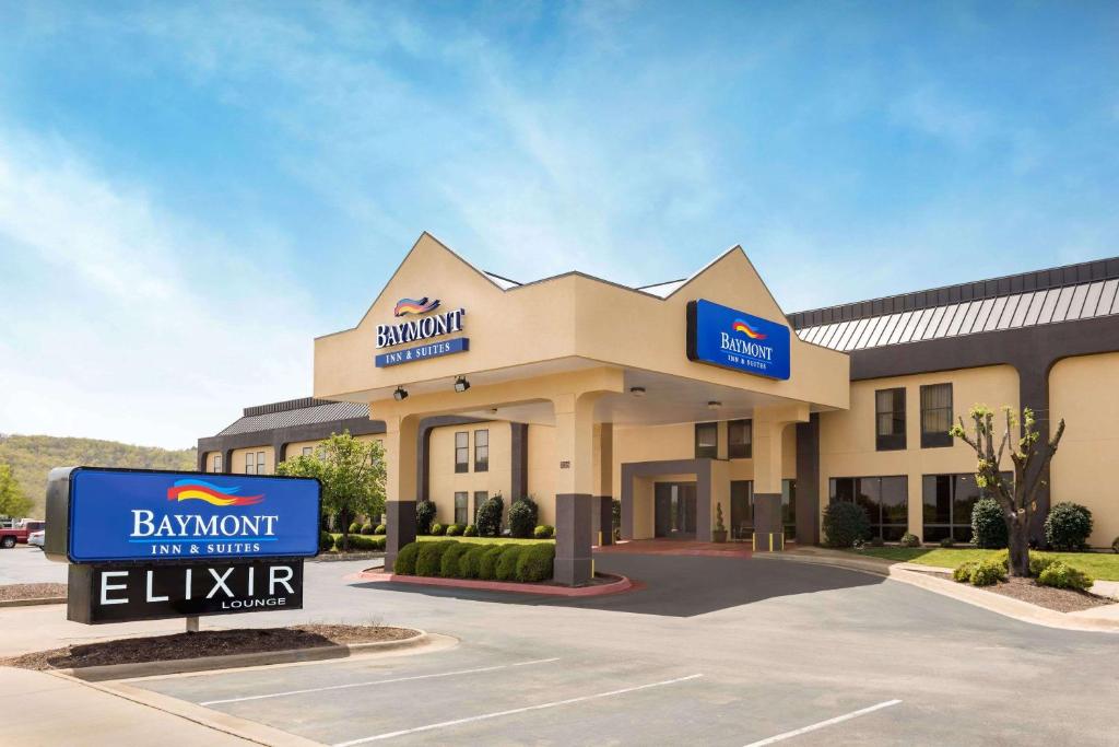 a hotel building with a sign in front of it at Baymont by Wyndham Fayetteville in Fayetteville