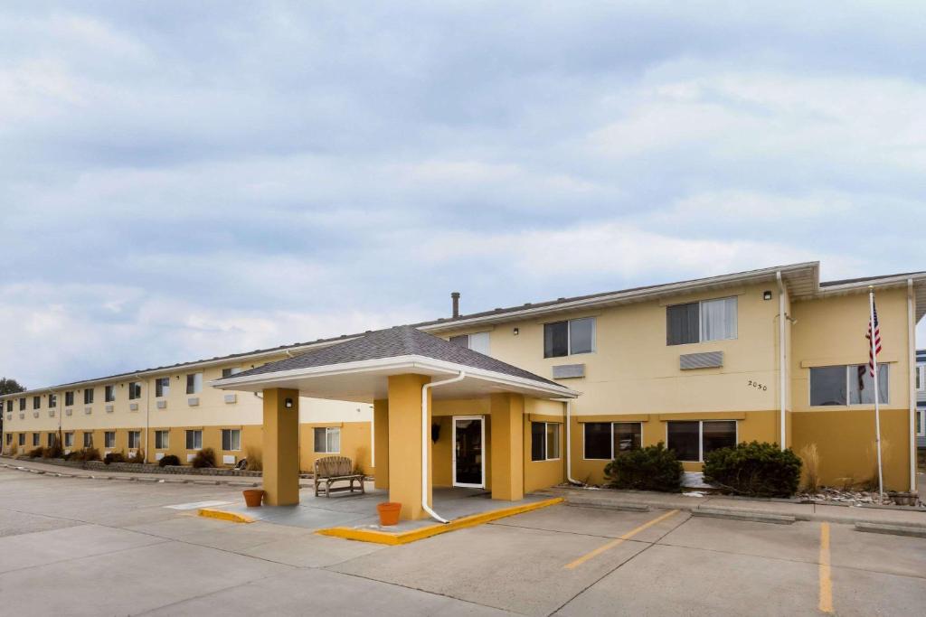 a large yellow building with a parking lot at Baymont by Wyndham Billings in Billings