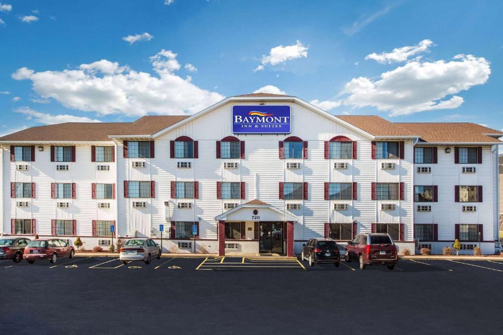 un gran edificio blanco con coches aparcados en un aparcamiento en Baymont by Wyndham Cedar Rapids en Cedar Rapids