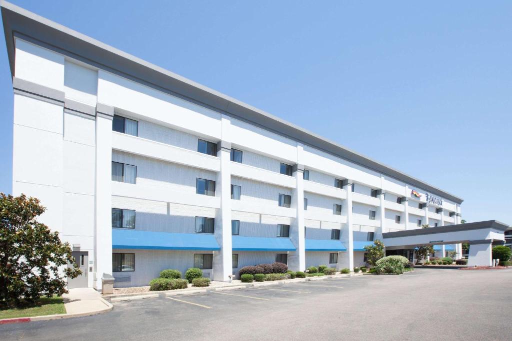 an exterior view of a large white building with blue accents at Baymont by Wyndham Texarkana in Texarkana