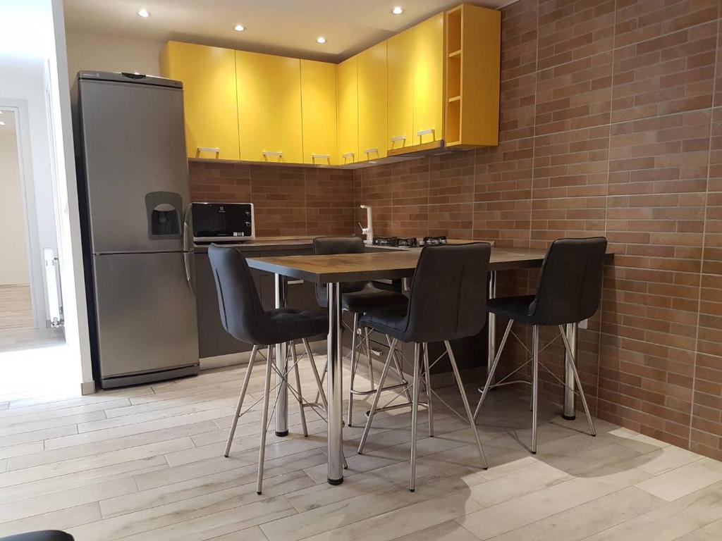 a kitchen with a table and chairs and a refrigerator at Apartman Sevilya in Kostrena