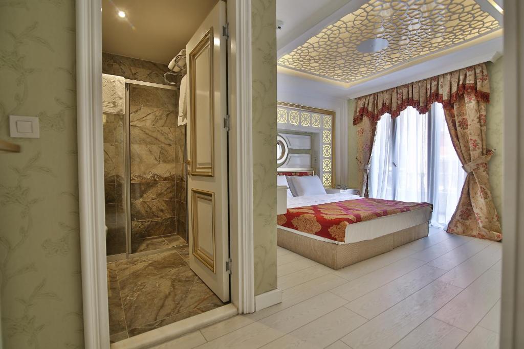 a bedroom with a bed and a walk in shower at Hotel Queens Land in Istanbul