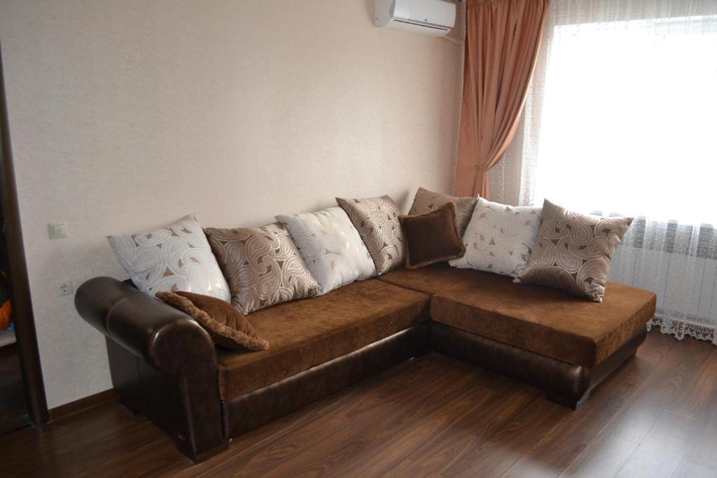 a brown couch with pillows on it in a living room at Гагарин in Pyatigorsk