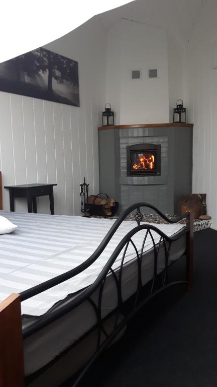 ein Schlafzimmer mit einem Bett und einem Kamin in der Unterkunft Apartamentai Birštono centre su židiniu in Birštonas