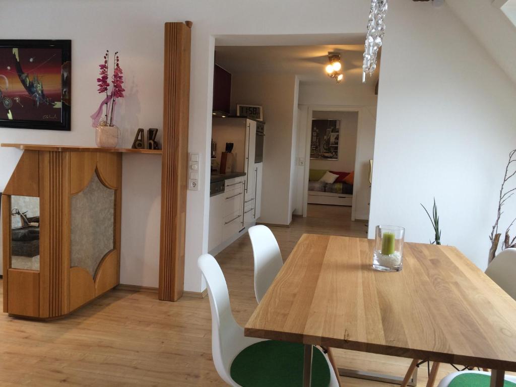 uma cozinha e sala de jantar com uma mesa de madeira e cadeiras em Alte Schreinerei em Veringendorf