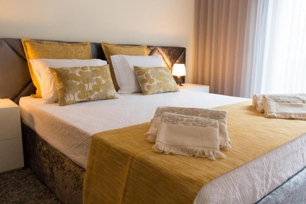 a hotel room with two beds with pillows at Apartamento Latino Coelho in Póvoa de Varzim