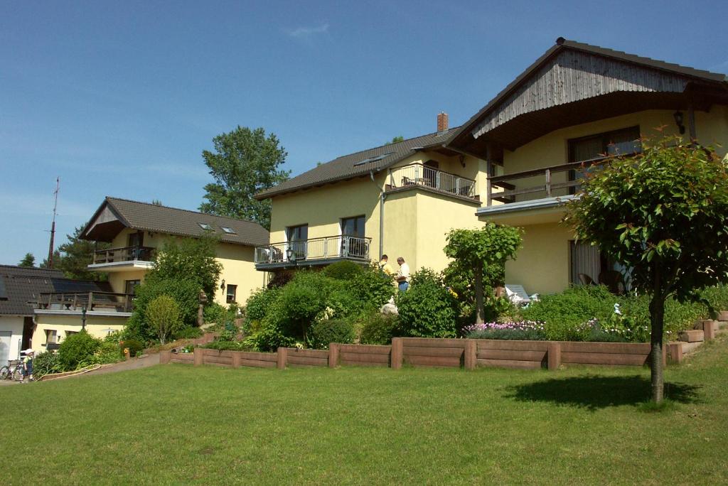 a large house with a fence in front of a yard at An den beiden Krebsseen - Ferienhäuser-Wohnungen in Bansin