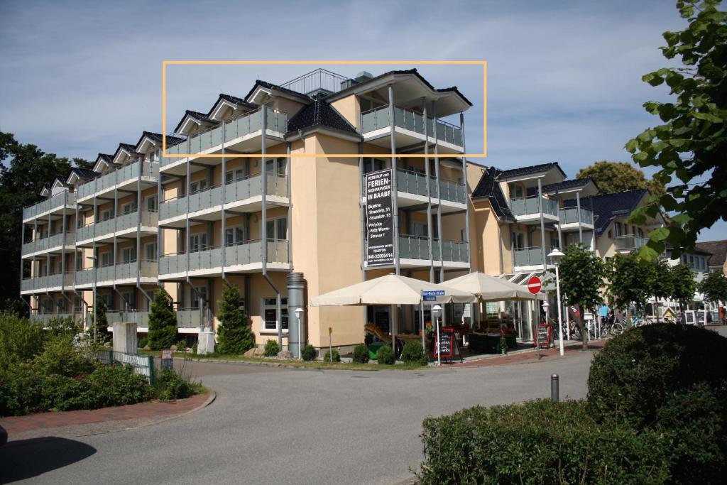 a large apartment building on a street with umbrellas at Kiekut in Baabe