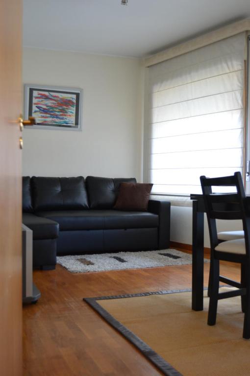 un soggiorno con divano nero e tavolo di Life in Porto Apartment by JC a Porto