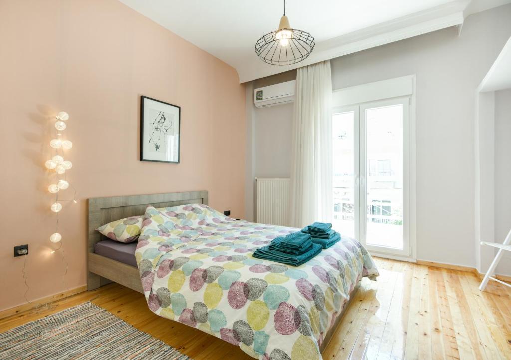 ein Schlafzimmer mit einem Bett und einem großen Fenster in der Unterkunft Style 'n' Comfort in Thessaloniki