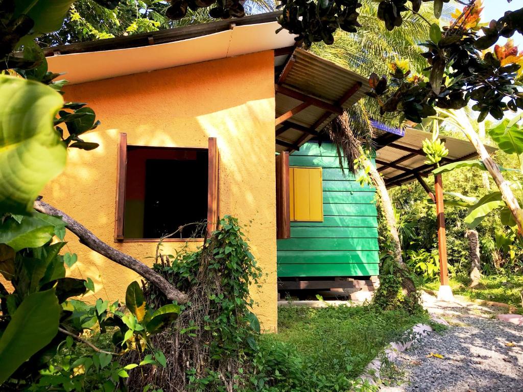 una pequeña casa con un verde y naranja en Casita Rolando, en Puerto Viejo