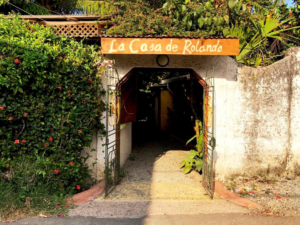 a narrow alleyway leads to a building with a clock on it at La Casa de Rolando in Puerto Viejo
