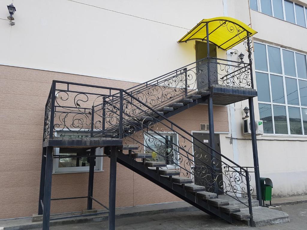 a staircase with a yellow umbrella on the side of a building at Sport Hotel in Slavyanka