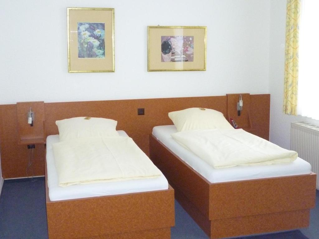 ヘンミンゲンにあるHotel-Gaststätte Mutter Buermannのツインベッド2台が備わる2名用の客室です。