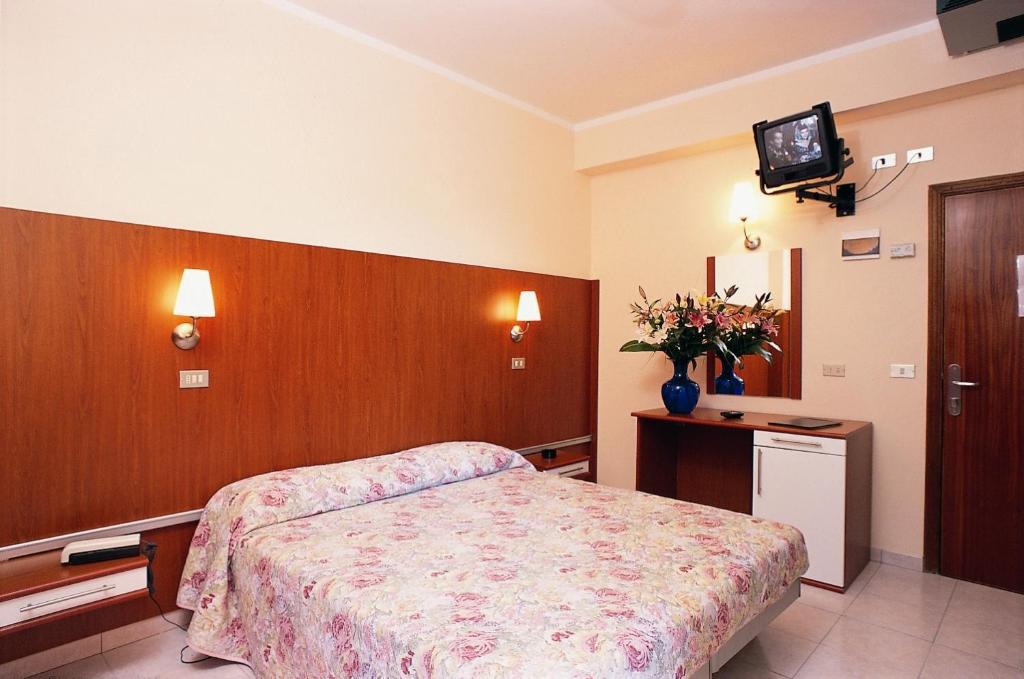 a bedroom with a bed and a tv on a wall at Park Hotel Miriam in Gatteo a Mare