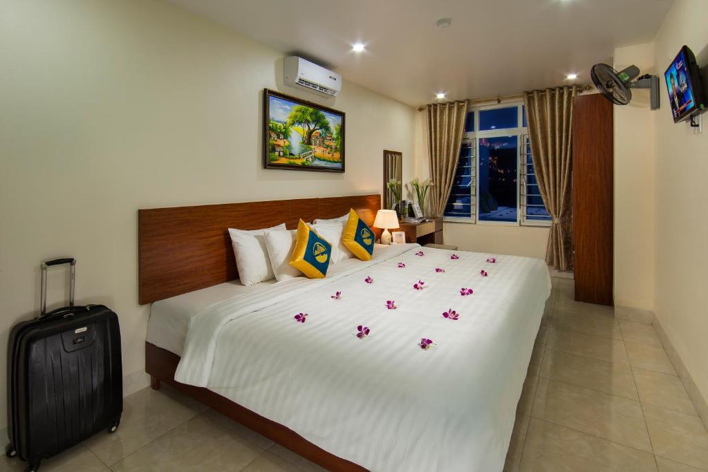 - une chambre avec un grand lit blanc orné de fleurs dans l'établissement Cannon Fort Cat Ba Hotel, à Cat Ba