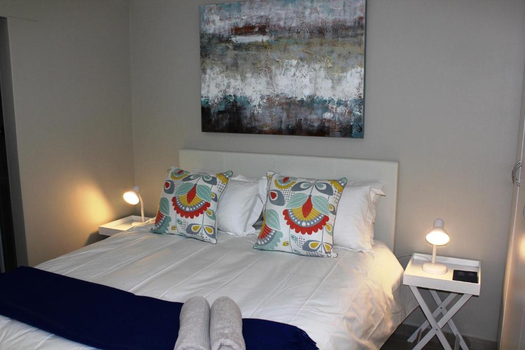 a bedroom with a bed with white sheets and pillows at The Nook in Langebaan