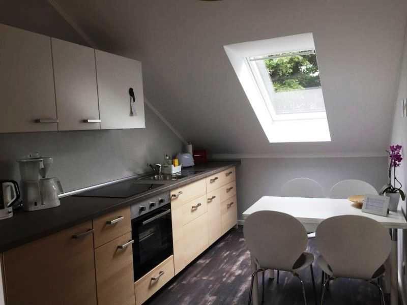 een keuken met een tafel en stoelen en een raam bij fewo anderswo in der Nähe von Stralsund in Pantelitz