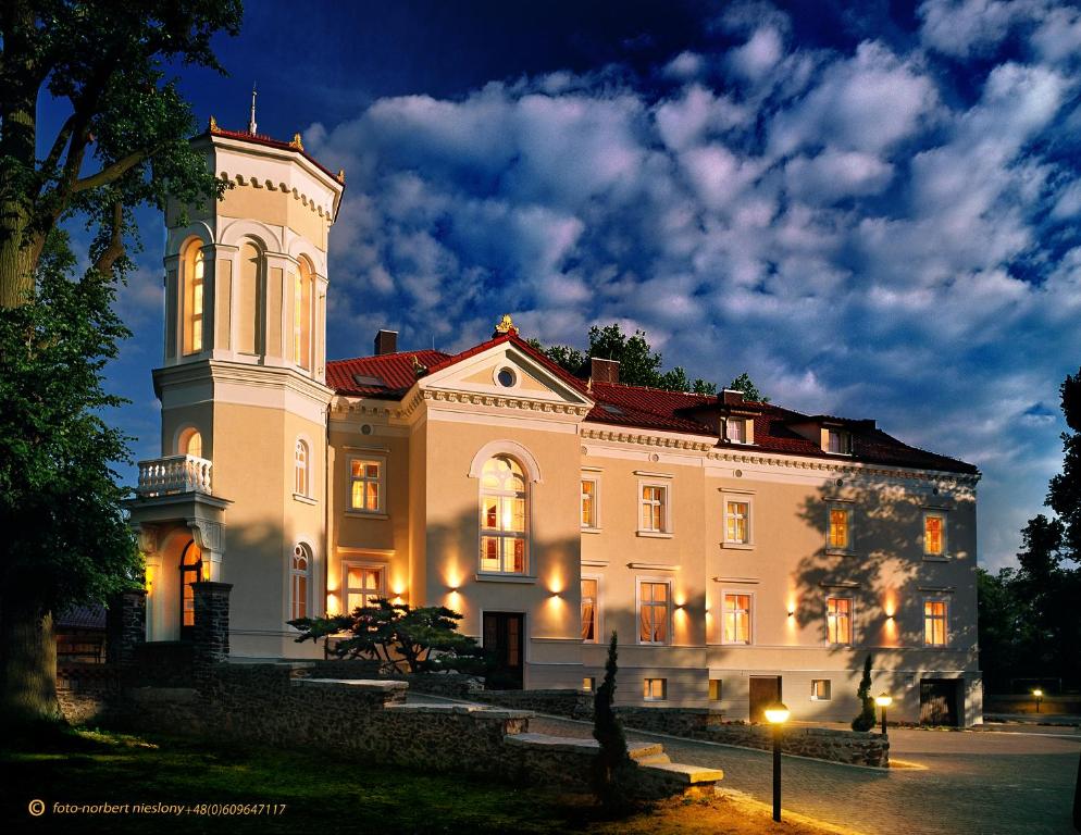 duży biały budynek z wieżą w nocy w obiekcie Pałac Pawłowice w mieście Gorz