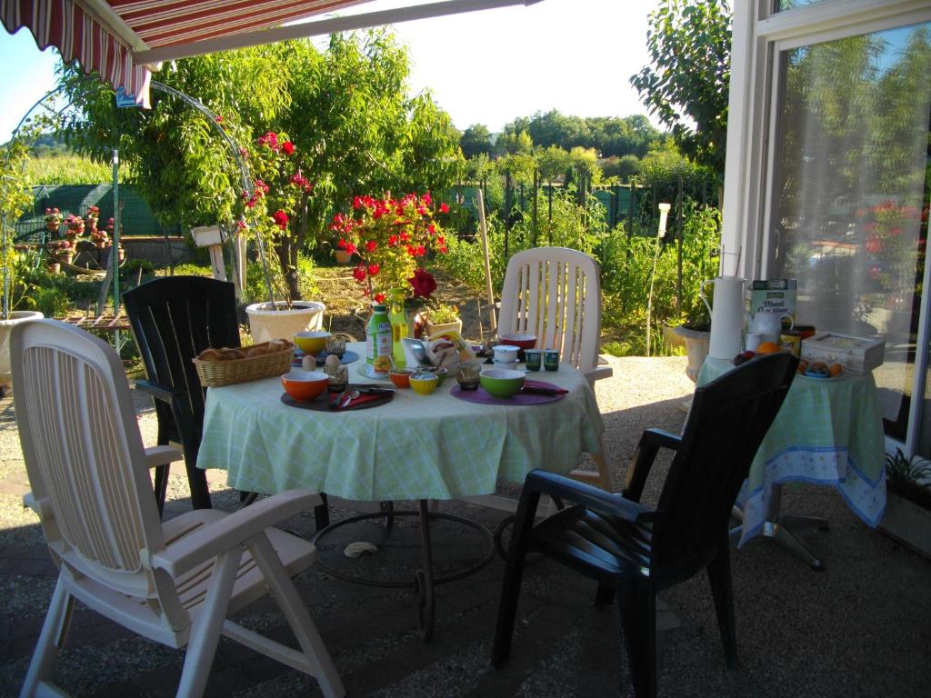 a table with chairs and a table with food on it at La Nouste Maisoun in Barcelonne-du-Gers