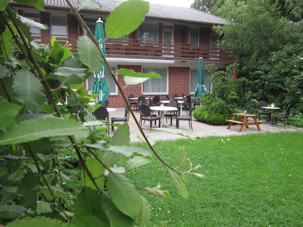 a patio with tables and chairs in a yard at Hotel Möllner Hof in Welt