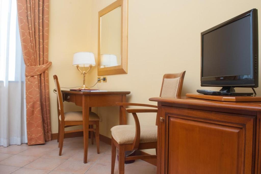 TV a/nebo společenská místnost v ubytování Le Cheminée Business Hotel Napoli