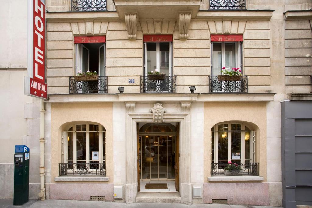 een gevel van een gebouw met ramen en balkons bij L'Amiral in Parijs