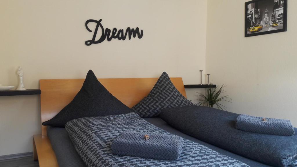 una cama con almohadas negras y un cartel que diga: en Schrammi's Ferienwohnung, en Schwanau