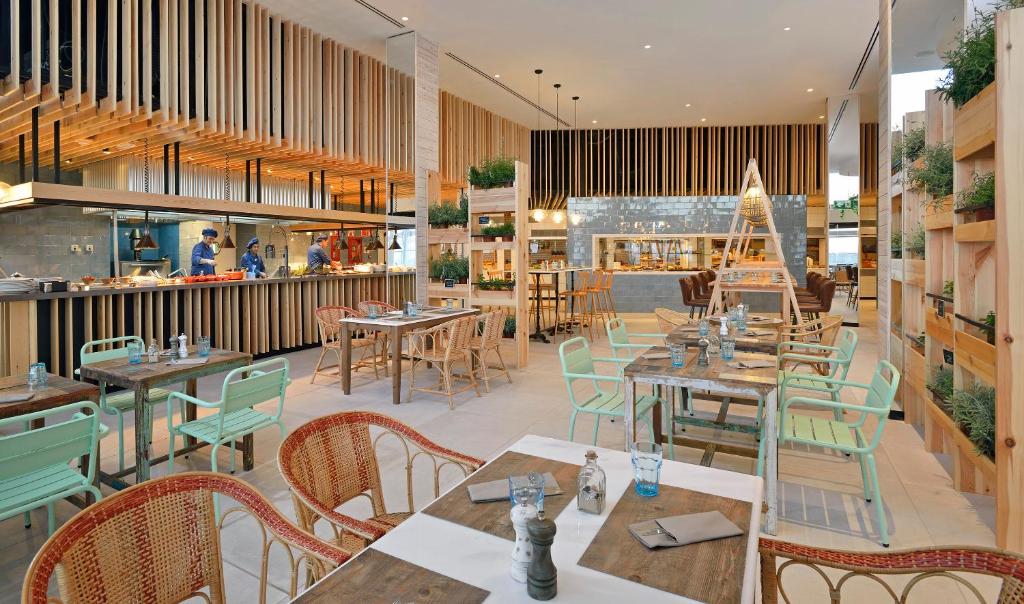 a restaurant with wooden tables and chairs and a restaurant at INNSiDE by Meliá Fuerteventura – Adults Only in Costa Calma