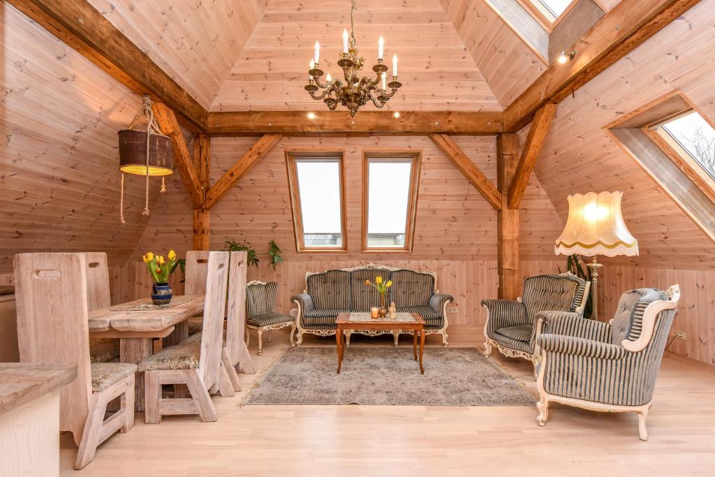 a living room with a wooden ceiling with a chandelier at KUBU 4-rooms apartment in Klaipėda