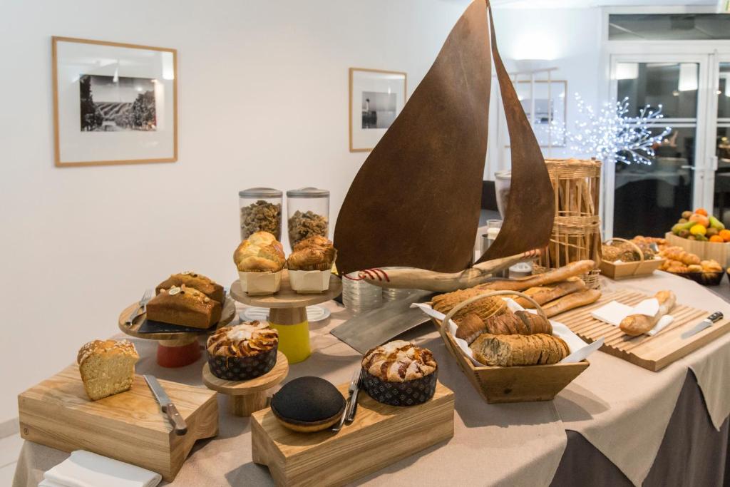 a table with many different types of bread and pastries at Thalacap Île de Ré - Thalasso & Spa in Ars-en-Ré