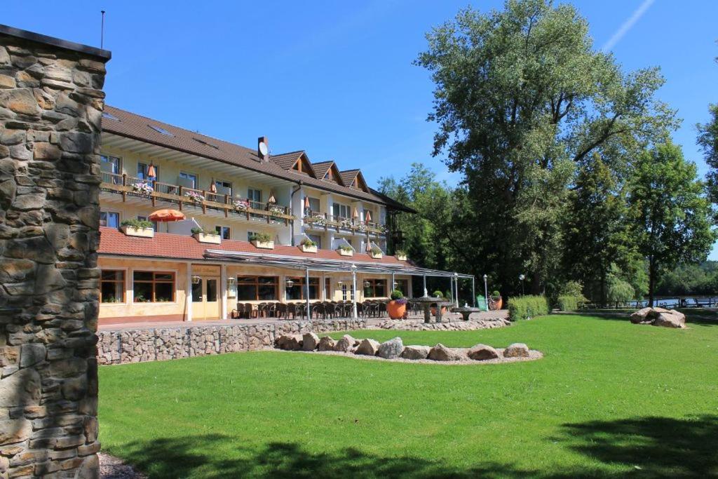 a large building with a grass yard in front of it at Hotel Salinensee in Bad Dürrheim