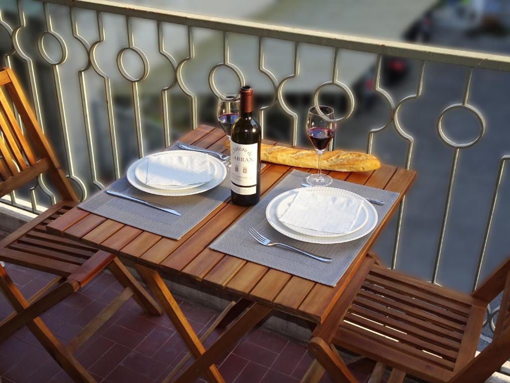 uma mesa com uma garrafa de vinho e uma fatia de pizza em Le Sunlight, quiet and cosy with terrace! em Nice