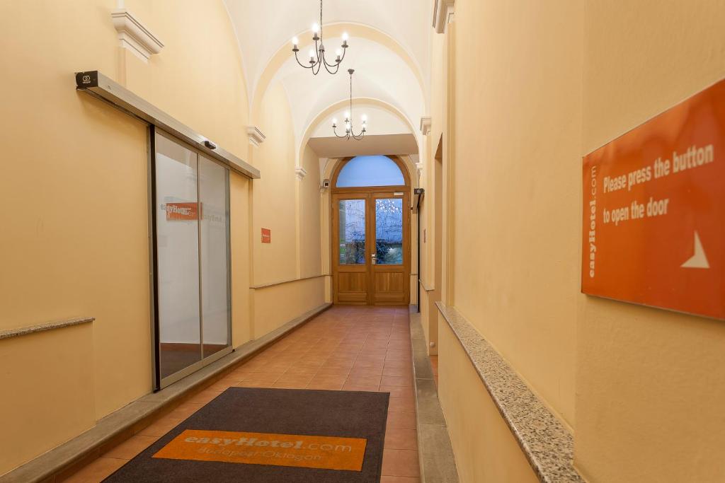 a hallway in a building with a door and a rug at easyHotel Budapest Oktogon in Budapest