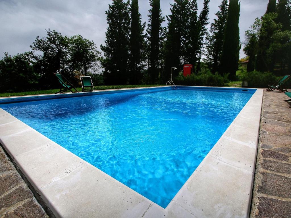 una piscina con acqua blu in un cortile di Beautiful Cottage in Scheggia with Swimming Pool a Misciano