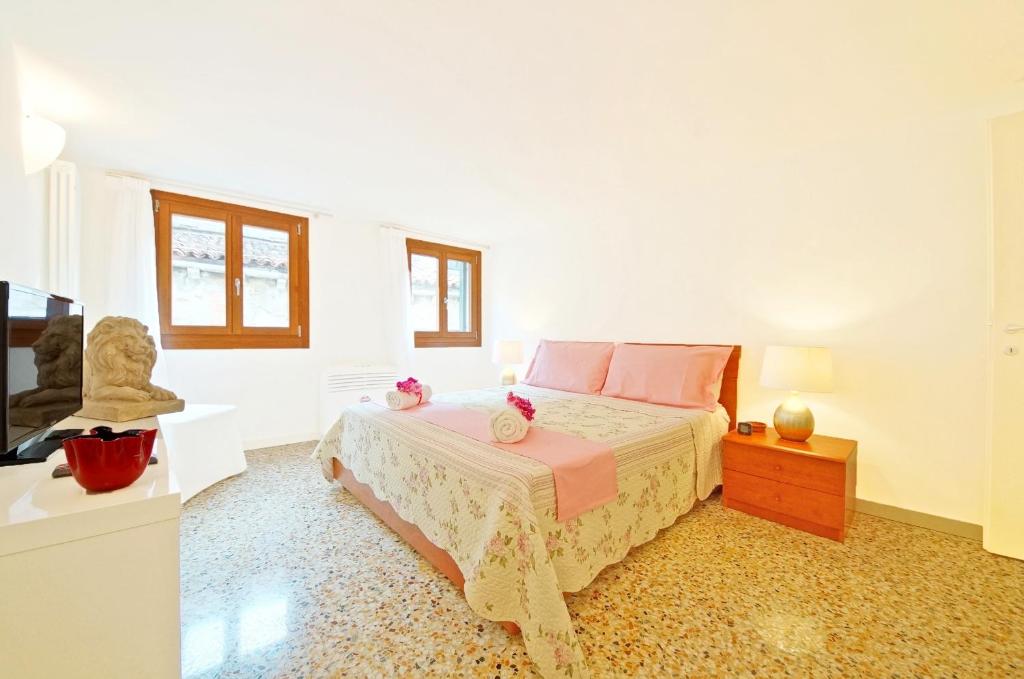 Habitación blanca con cama y TV en Sant'Aponal Apartment Rialto, en Venecia