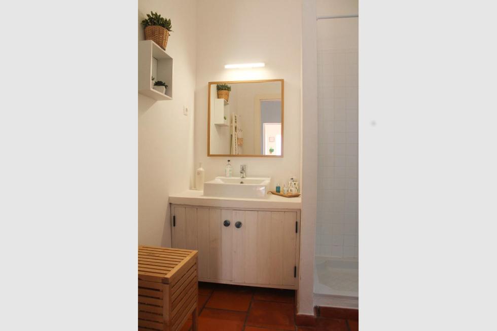 a bathroom with a sink and a mirror at Comporta House in Comporta