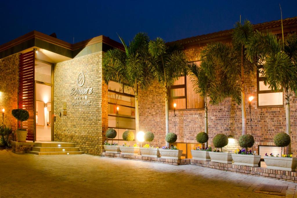 a building with palm trees in front of it at Schneiders Boutique Hotel in White River