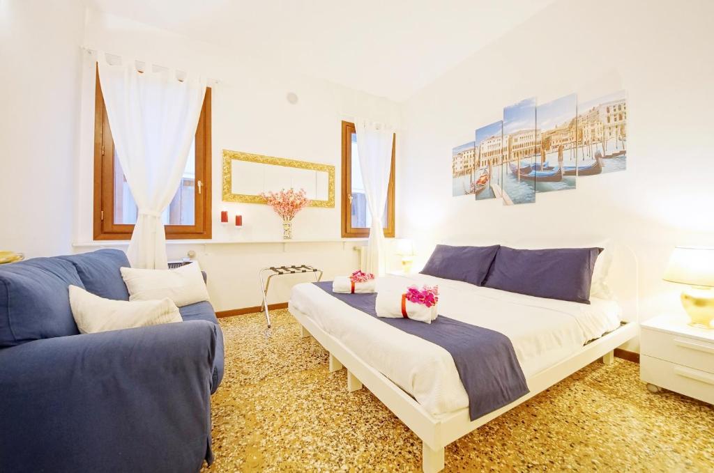 a bedroom with a large bed and two blue couches at Santa Marina Apartment Rialto in Venice